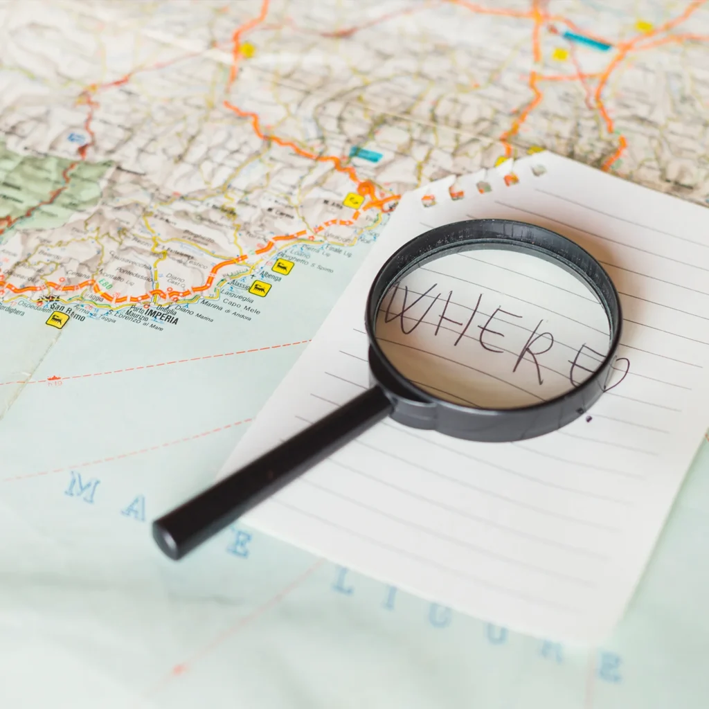 A magnifying glass highlights a flood map while selling a house in a flood zone Arizona requires careful review.